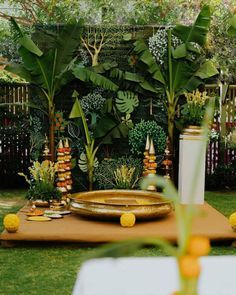 a table with plates and vases on it in the middle of a yard area