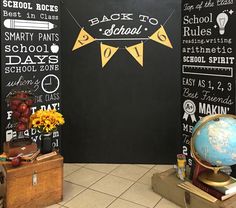 the back to school chalkboard wall is decorated with yellow pennants and other decorations