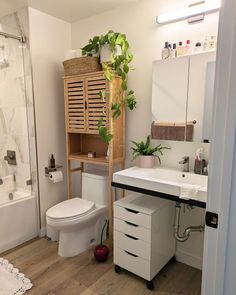 a bathroom with a sink, toilet and shower stall in the corner next to a bathtub