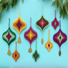 four ornaments hanging from a tree on a blue background