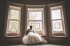 a bride sitting in front of three windows