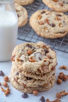 several cookies stacked on top of each other next to a bottle of milk and some nuts