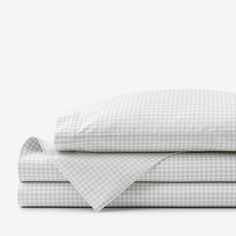 the sheets and pillowcases are folded up on top of each other in white checkers