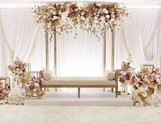 a white and gold wedding set up with flowers