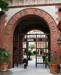 a woman standing in front of an iron gate with the words lager college on it