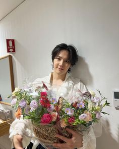 a woman holding a basket full of flowers