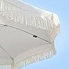 a white umbrella with fringes on it against a blue sky