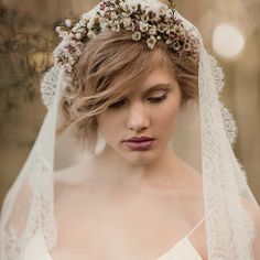 a woman wearing a veil with flowers in her hair