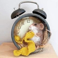 an old fashioned alarm clock with a rat in it's nest on top of a table