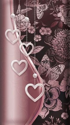 a pink vase with two hearts hanging from it's side on a floral background