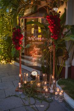 candles and flowers are arranged in front of a welcome sign