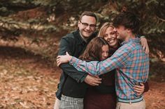 a group of friends hugging each other in the woods