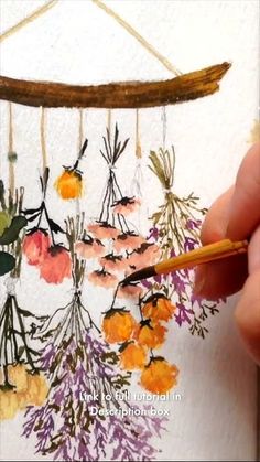 a person is drawing flowers on a piece of paper with a pencil and watercolor