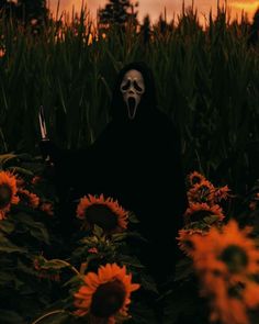 a person wearing a mask and holding a knife in a field of sunflowers