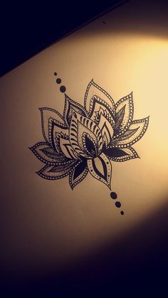 a drawing of a lotus flower on the side of a laptop computer with dots and circles around it