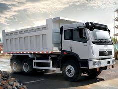 a white dump truck parked in front of a building