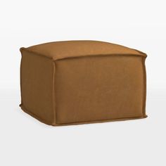 a small brown ottoman sitting on top of a white floor