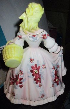 a ceramic figurine with corn on the cob in it's hand