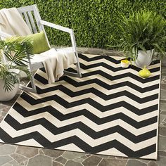 a black and white area rug with a chair on the ground in front of it