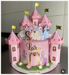 there is a pink cake with princess figures on it