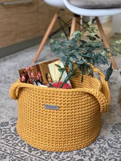 a yellow basket filled with books on top of a rug