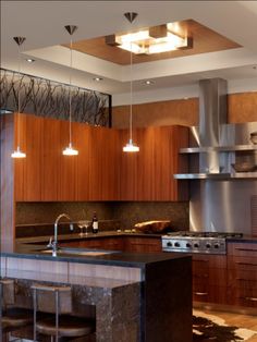 a modern kitchen with stainless steel appliances and wood cabinets