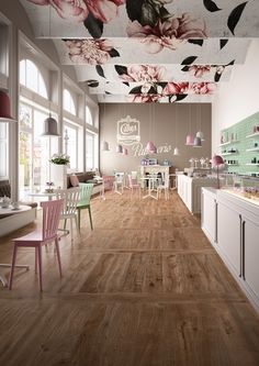 the interior of a restaurant with wooden flooring and floral ceiling tiles on the walls