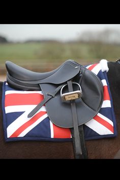 a horse with a saddle on it's back and the british flag covering its face