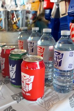 several different types of bottled water on a table with other bottles and containers behind them