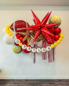 a football themed balloon wall hanging on the side of a room with balloons and decorations