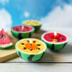 some watermelon slices are sitting on a cutting board with a candle in the middle