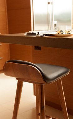 a wooden stool sitting in front of a counter top