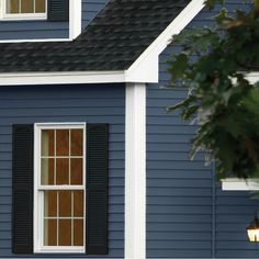 a white house with black shutters and a lamp