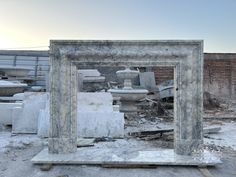 an old mirror sitting in the middle of a pile of rubble and broken down furniture