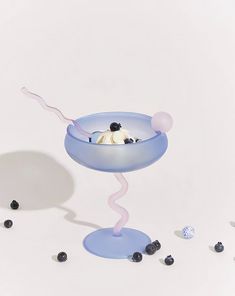 a blue bowl filled with ice cream and blackberries on top of a white table