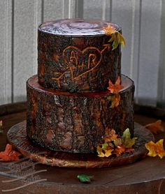 a three tiered cake decorated with leaves and initials