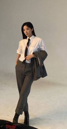 a woman in business attire standing on a surfboard with her hands behind her back