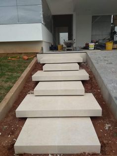 concrete steps are lined up in front of a building that is being built into the ground