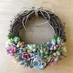 a wreath with succulents is hanging on the wall