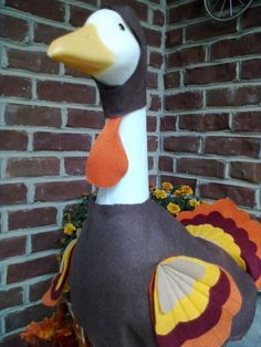 a stuffed turkey sitting in front of a brick wall