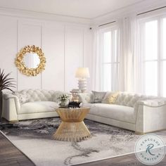 a living room filled with white furniture and lots of window sill space next to a round mirror on the wall