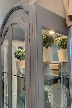 an old china cabinet with glass doors and flowers in the top one is painted white