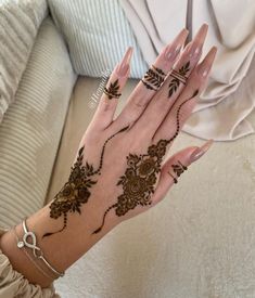 a woman's hand with henna tattoos on it