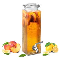 a glass beverage dispenser filled with peaches and lemons