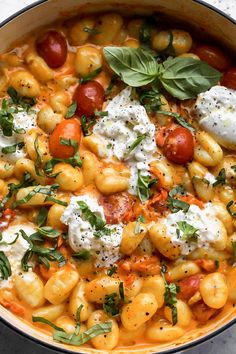 a pot filled with pasta and vegetables on top of a table