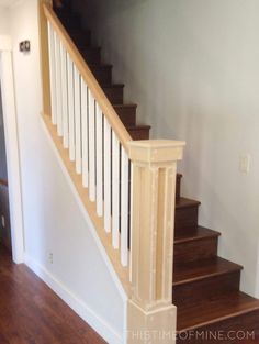 an empty room with stairs and hard wood flooring on the bottom half of it