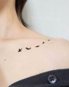 a woman's chest with birds flying in the sky on her left shoulder and right breast