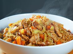 a white bowl filled with food on top of a wooden table