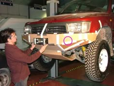 a woman is working on the front bumper of a truck