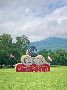 a large stone sign with the word god, blessing america written on it in front of mountains